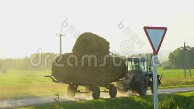 农民用拖拉机耕作农田. 拖拉机驾驶干草捆。 农业农村农场，农民